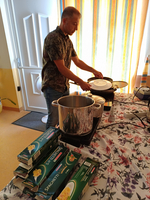 Ein Mann kocht Spaghetti in einer Küche mit mehreren Paketen auf dem Tisch.