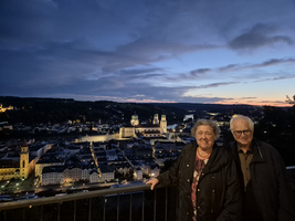 Ein Paar steht vor einer Stadtansicht bei Sonnenuntergang.