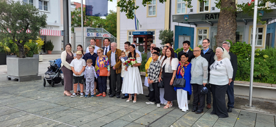 Eine Gruppe von Menschen feiert eine Hochzeitszeremonie im Freien.