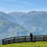 Blick auf beeindruckende Berge mit einer Person am Geländer.